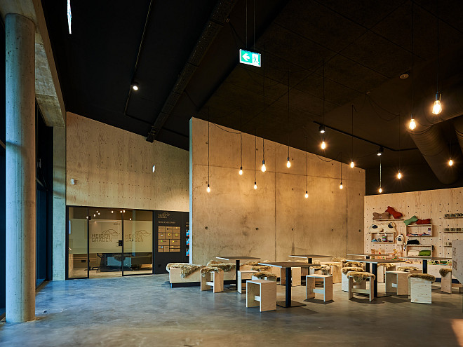 Ein modern eingerichtetes Bistro, Holz und Beton sowie eine warme Beleuchtung geben einen modernen Ton.