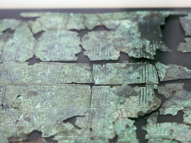 Ein mit Grünspan besetzter historischer Metallbeschlag auf schwarzem Untergrund